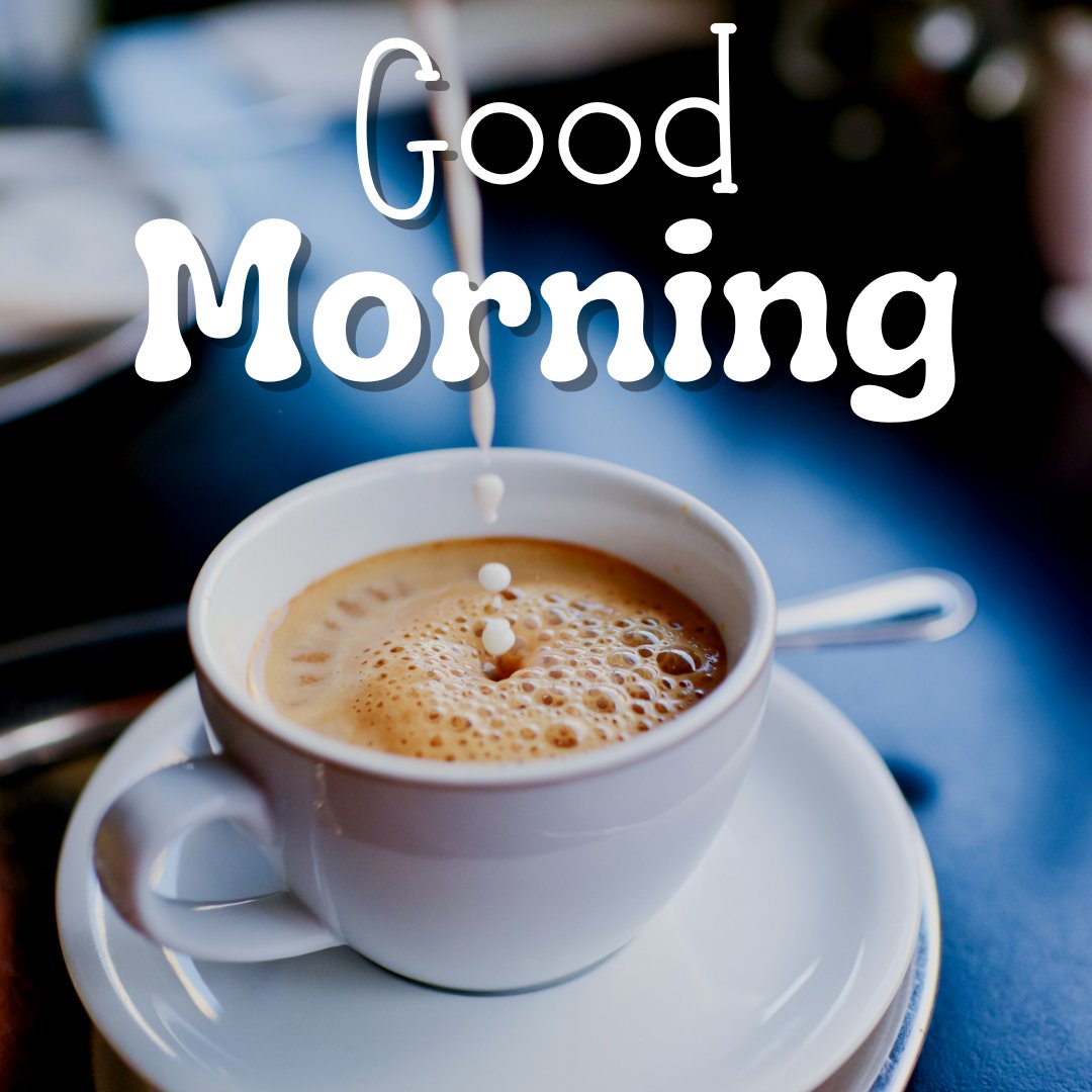 Dynamic good morning coffee image capturing a splash of milk being poured into a frothy coffee in a white cup, with 'Good Morning' text floating above, all set against a blue table background