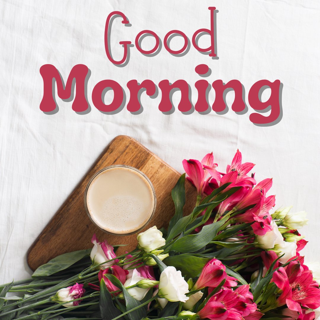 Beautiful good morning coffee image featuring a creamy latte on a wooden cutting board, surrounded by a lush bouquet of red and white flowers, with bold 'Good Morning' text on a soft white linen background